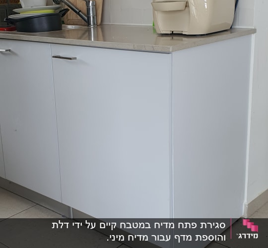 מטבח עם ארונות עץ ולוח חיתוך